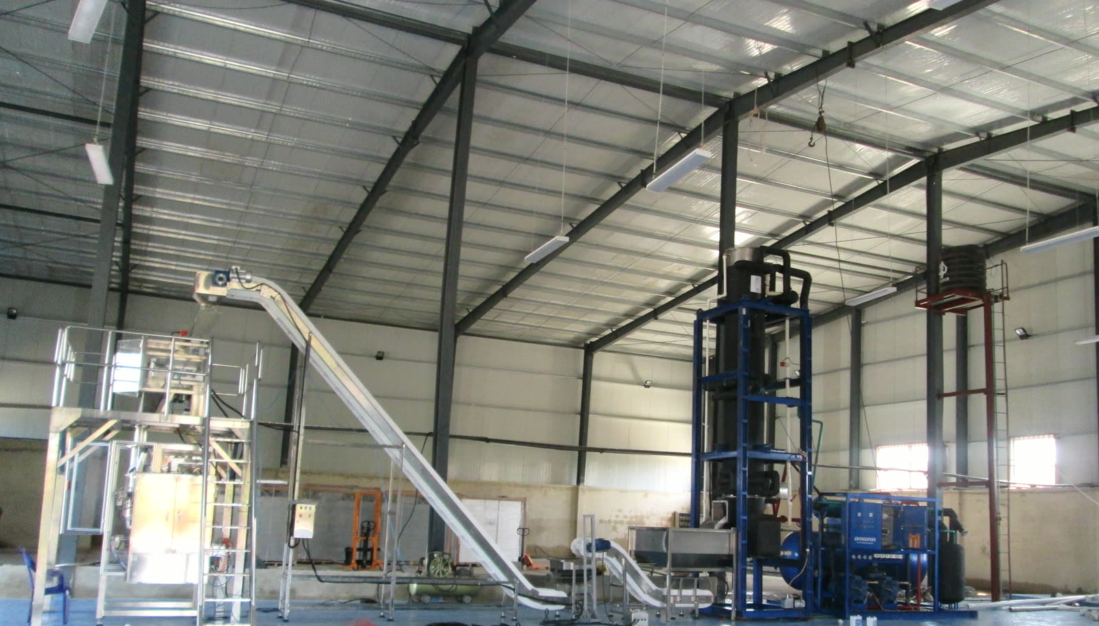 Línea automática de envasado de hielo con equipo de refrigeración en taller industrial